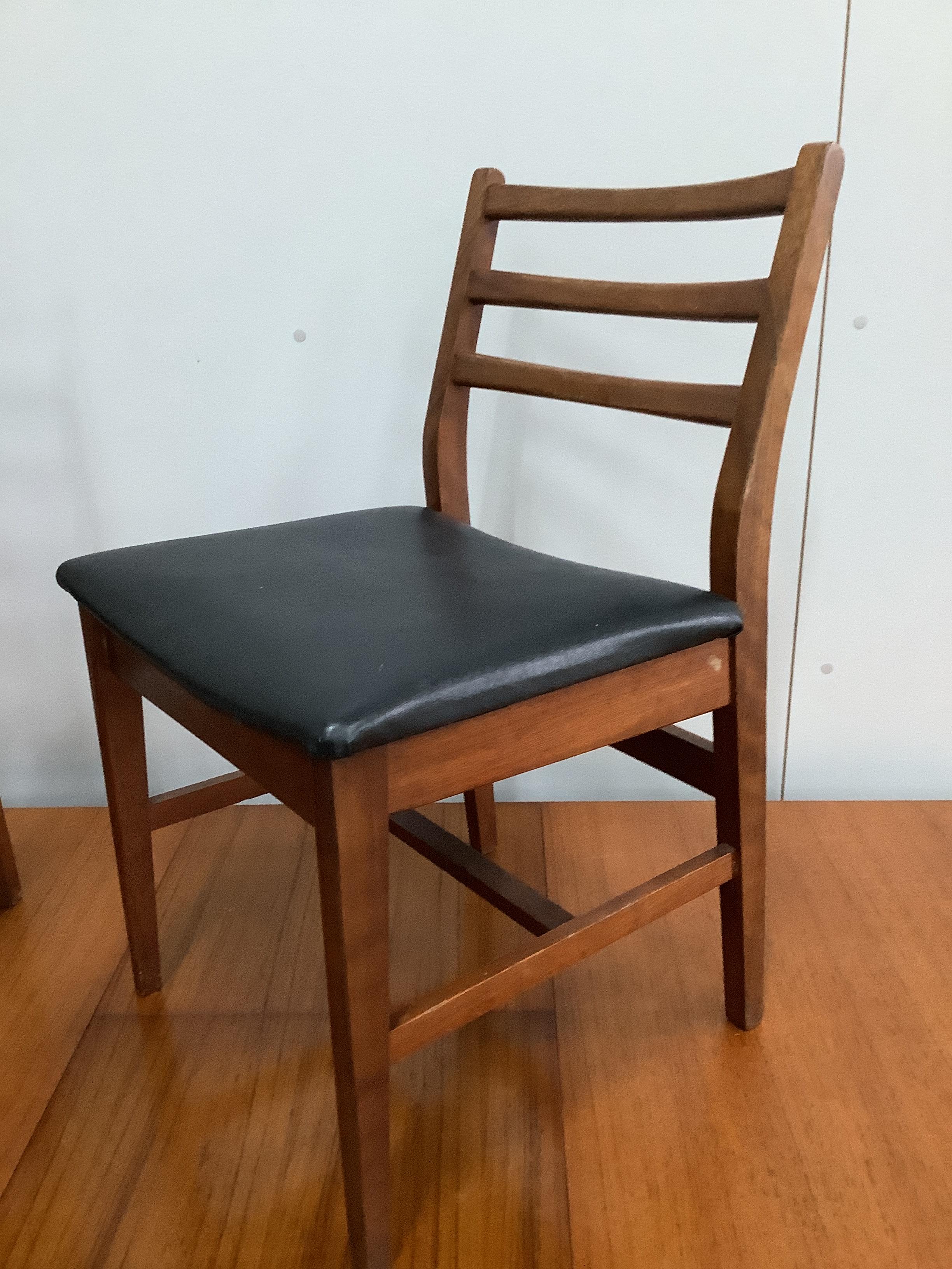 A mid century Danish design teak extending dining table, 184cm extended, width 86cm, height 73cm and six chairs with black leatherette seats